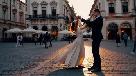 couple dancing in a city square at sunset