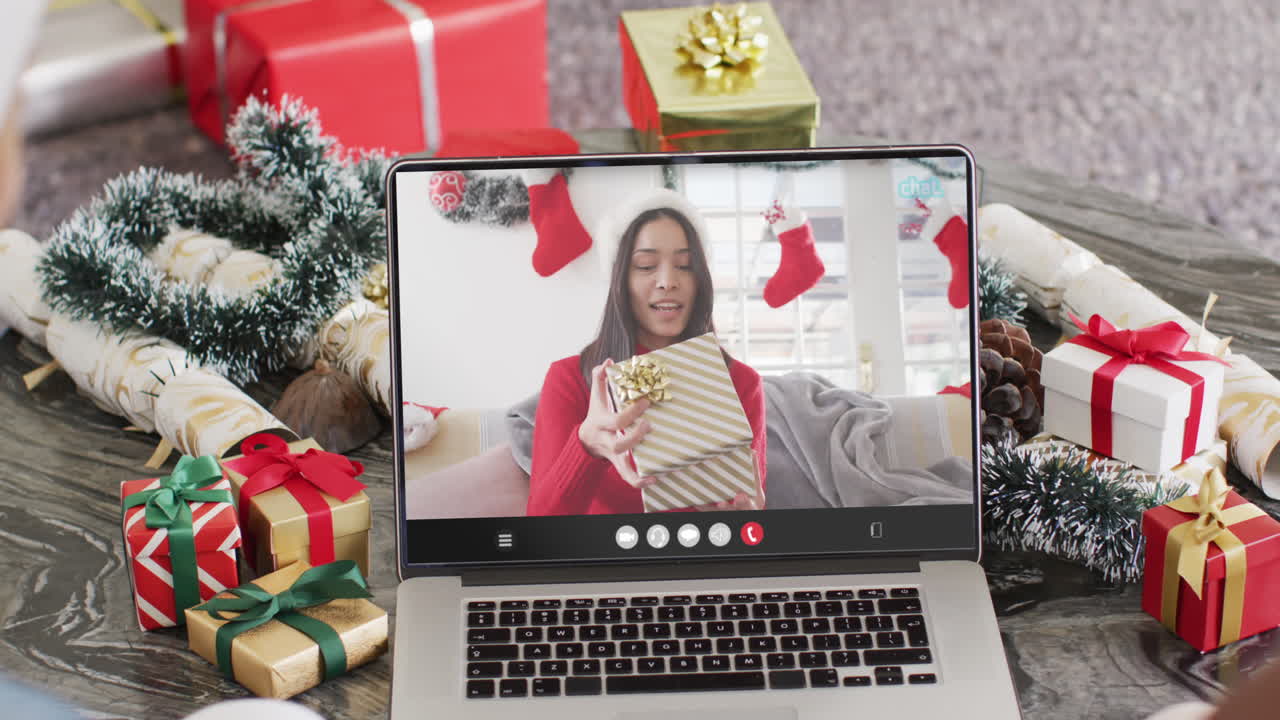 una pareja diversa tiene una llamada de video de navidad con una mujer biracial.