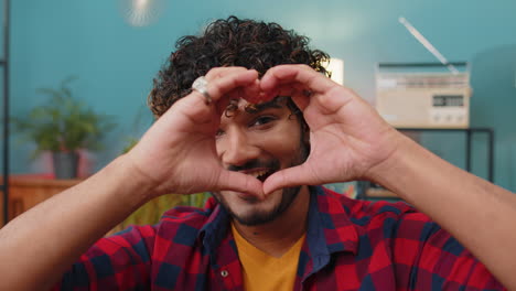 Happy-indian-man-guy-makes-symbol-of-love-showing-heart-sign-to-camera-express-romantic-feelings