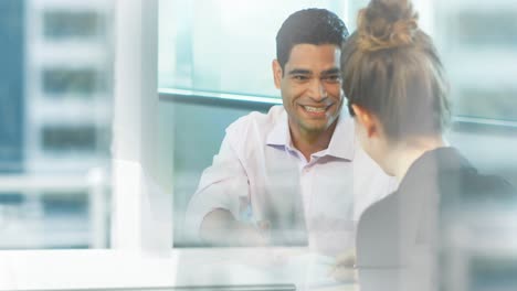 Animation-of-businessman-and-businesswoman-talking-and-shaking-hands-in-office