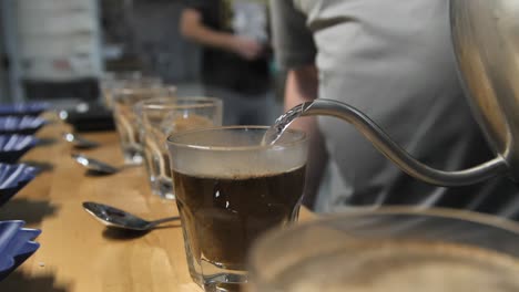 pour hot steamy water to begin the coffee taste test, slow motion close up