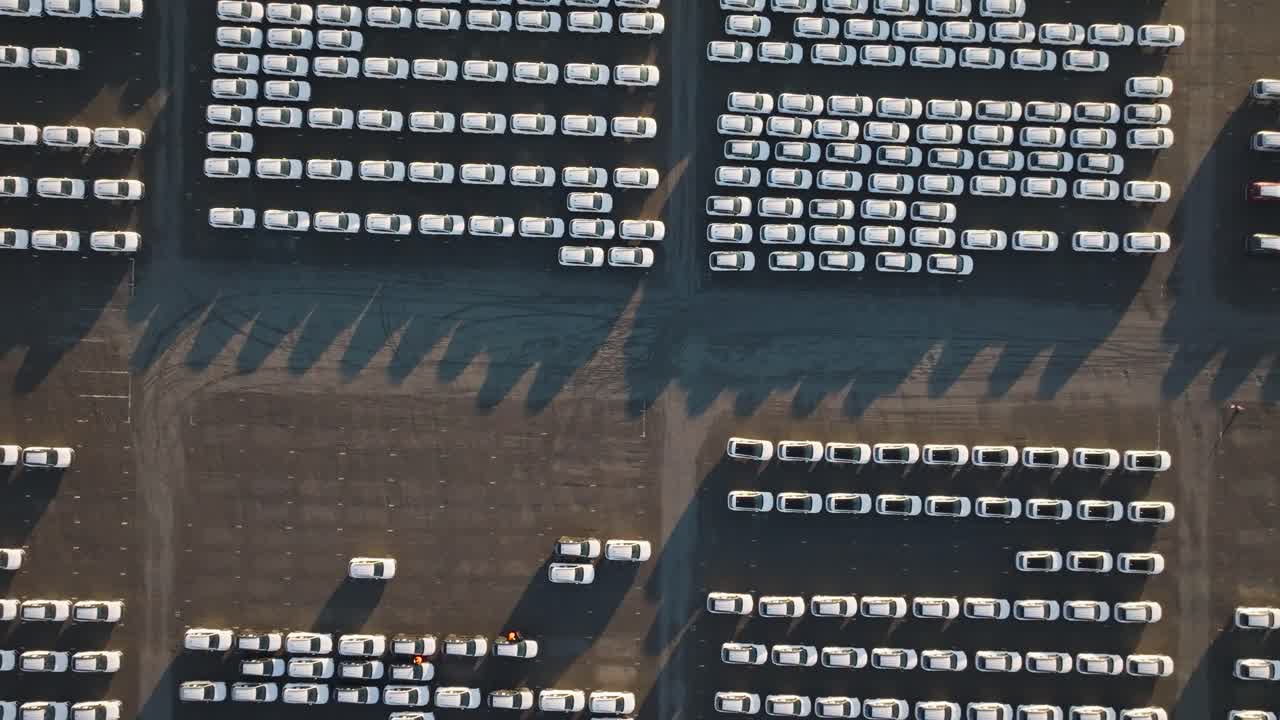 Aerial top down descend over parking lot with identical cars