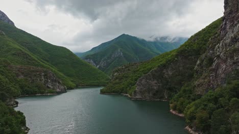 Wide aerial pull-out of Lake Koman and green mountains in Albania