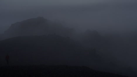 dramatic iceland landscape at night, camera movement, camera pan from right to left to reveal a person walking towards the camera