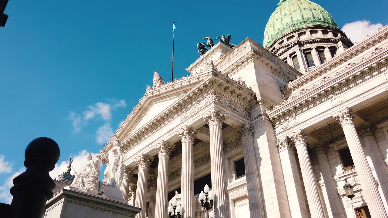 Inquadratura dal basso di colonne neoclassiche in marmo e statue del Palazzo del Congresso Nazionale Argentino a Buenos Aires.