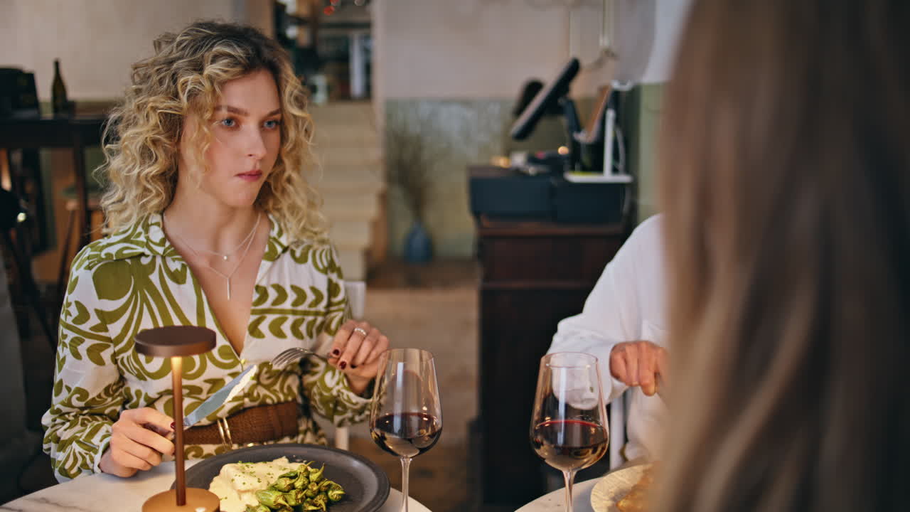 Group friends dining together and conversing at restaurant closeup. Three women