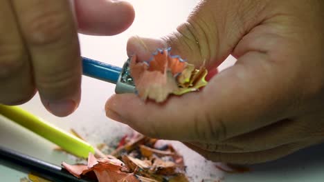 Imágenes-De-Manos-Afilando-Lentamente-Un-Lápiz-Y-Algunos-Lápices-De-Colores-Con-Un-Sacapuntas-De-Cuña