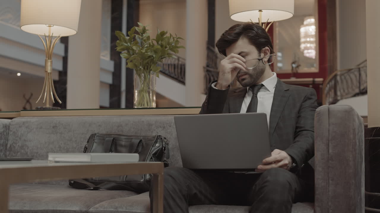 Man Posing with Laptop in Lobby