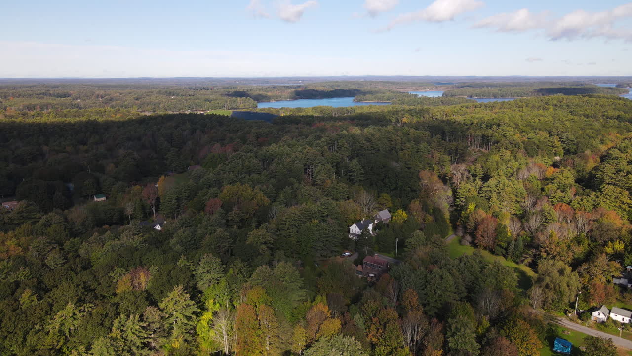 descenso aéreo de drones sobre el bosque con colores de otoño sobre la ciudad de bath, maine
