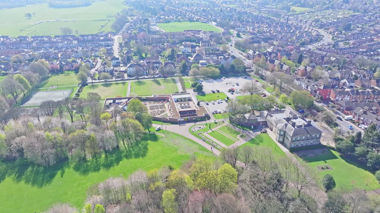 Spring aerial of green open park bordered by trees and curved trail system, Clifton Park Rotherham UK