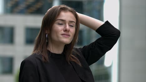 Young-female-professional-looks-up-at-buildings-in-the-city-brunette-slow-motion