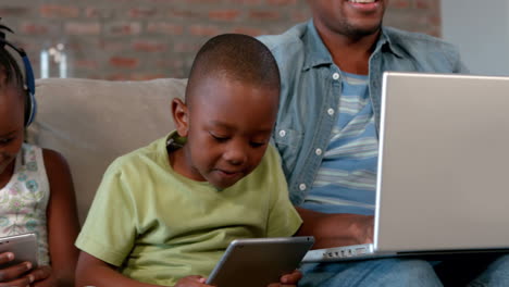 Family-using-media-devices-on-the-couch