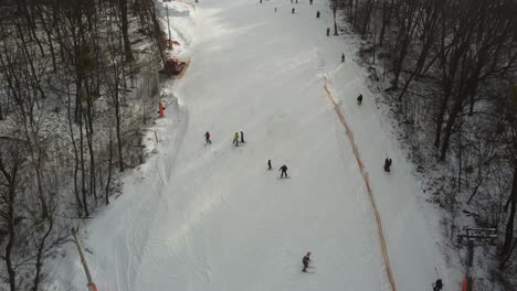 Drone-view-at-slope-on-ski-resort.-Forest-and-ski-slope-from-air.-Winter-landscape-from-a-drone.-Snowy-landscape-on-ski-resort.-Aerial-photography