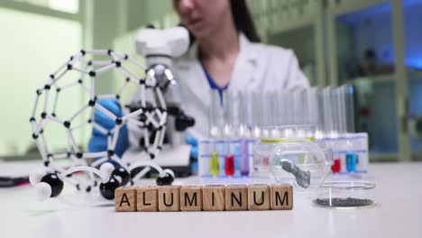 scientist in lab with aluminum and molecular models