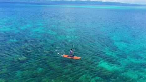 ponerse de pie remando en la superficie del mar poco profundo en el parque marino tagbak en el sur de leyte en verano