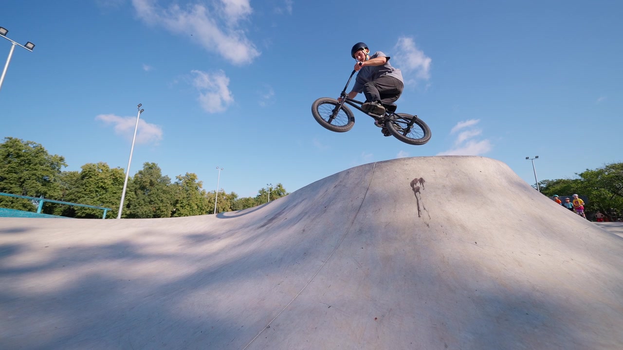 BMX-rytter springer over betonrampe i skatepark