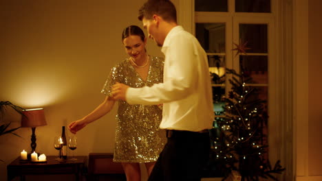 romantic couple dancing xmas tree interior closeup. woman man moving at evening