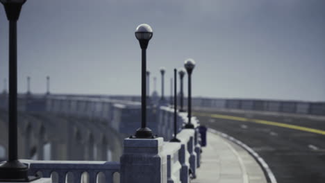view of street lamps along a winding bridge with an open road in the distance