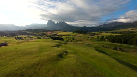 Cinematic-FPV-drone-shot-flying-above-the-plateau-of-Alpe-di-Siusi,-Seiser-Alm-meadows-at-sunrise-in-the-Dolomite-mountains,-Italian-Alps