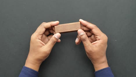 hands holding a hazelnut chocolate bar