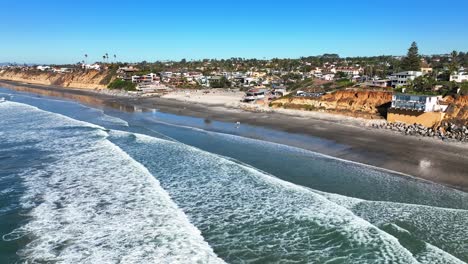 toma aérea hacia atrás de casas residenciales y hoteles a lo largo de las playas de encinitas, california, ee.uu. en un día soleado