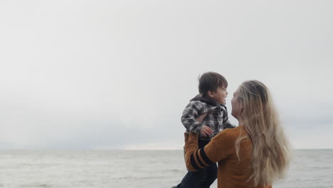 a young mother walks with her son on the shores of the picturesque lake ontario