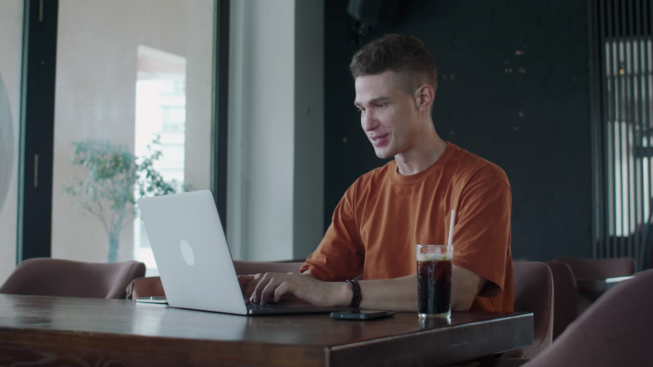 Happy Trader Getting Good News Sitting in front of Laptop in Cafe
