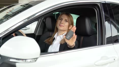 portrait of a young confident woman sitting in a new car at a car dealership