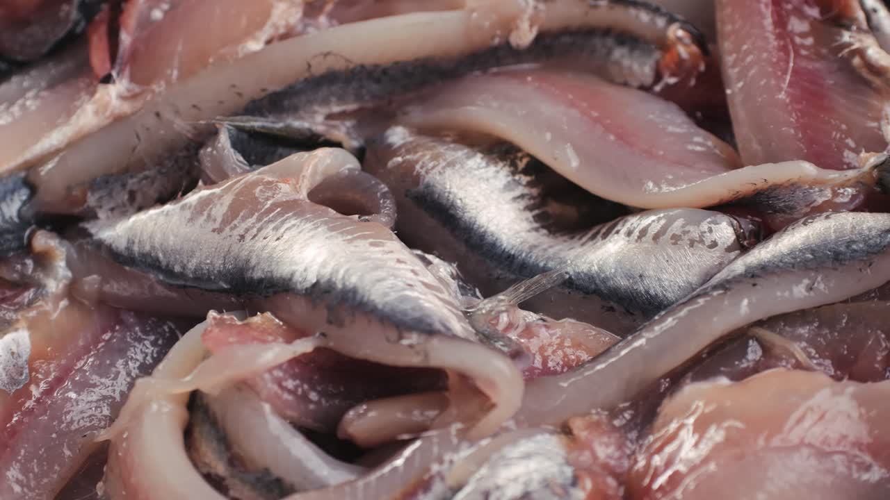 Fresh Sea sardines and Anchovy Fish and Mullus On Display On Ice On Market Store Shop. Seafood Fish Background, close up stand of small salty white fish.