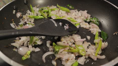 cerca, fritando verduras con aceite en la sartén en la cocina