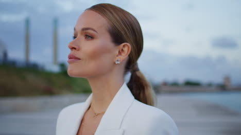 confident model posing cloudy sky background close up. businesswoman standing