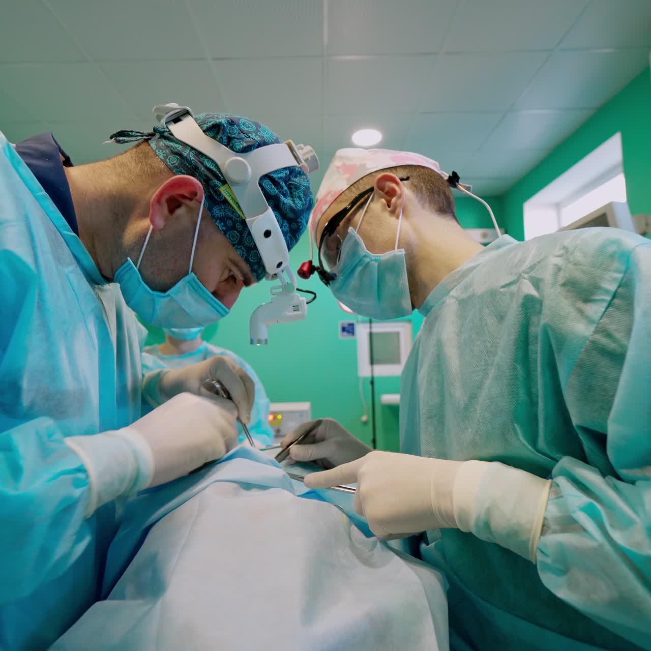 Doctors give resuscitation to a patient in the emergency room. Surgeons in medical masks fight for patient's life in the intensive care unit.