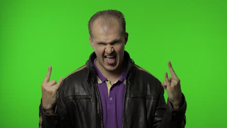 el hombre rocker mostrando el signo del rock and roll, el gesto de los cuernos del diablo, mirando con una expresión loca