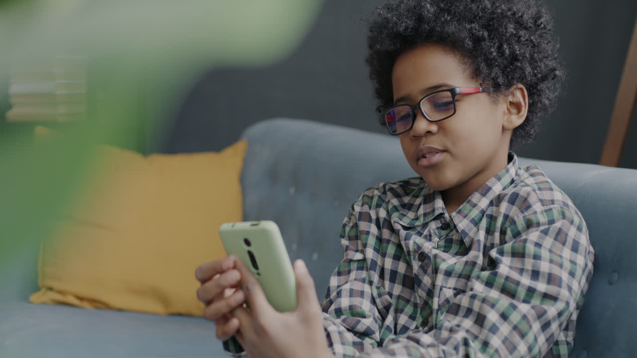 Boy using a smartphone on a couch