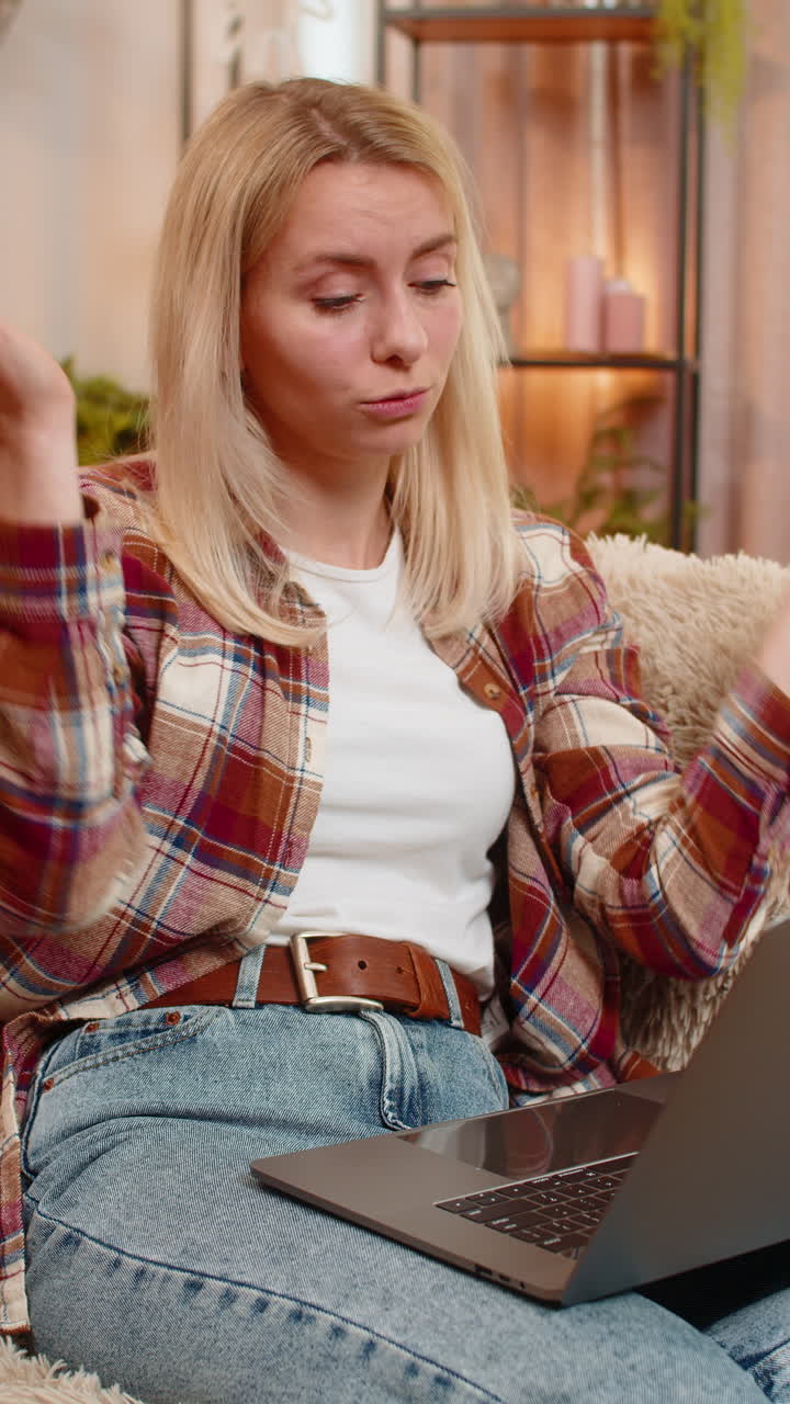 Adult woman reading email with bad news on laptop at home reacting with disappointment and stress