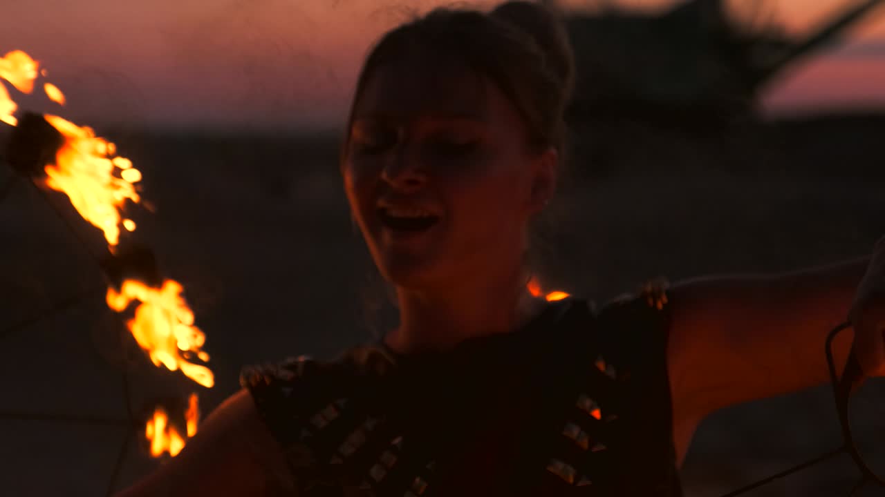 Professional dancers women make a fire show and pyrotechnic performance at the festival with burning sparkling torches.