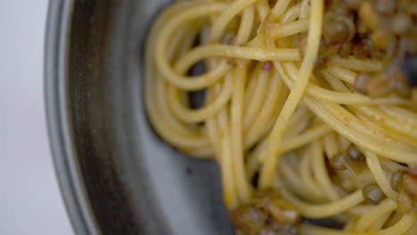 macro shot of vegan pasta, vegan lentil spaghetti dish, close up of spinning bowl of vegetarian pasta. plant based mushroom and lentil meal