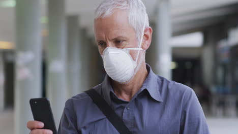 caucasian man out and about in the street wearing on a face mask against coronavirus