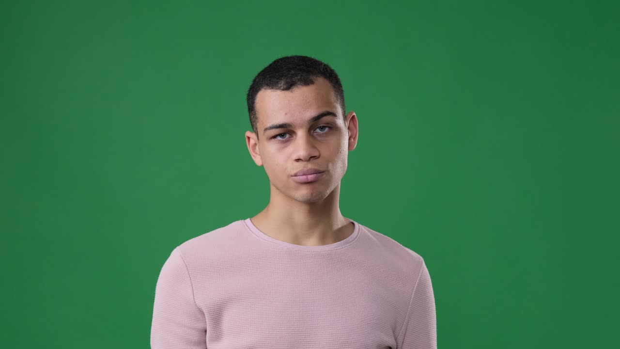 Man saying no by waving finger over green background