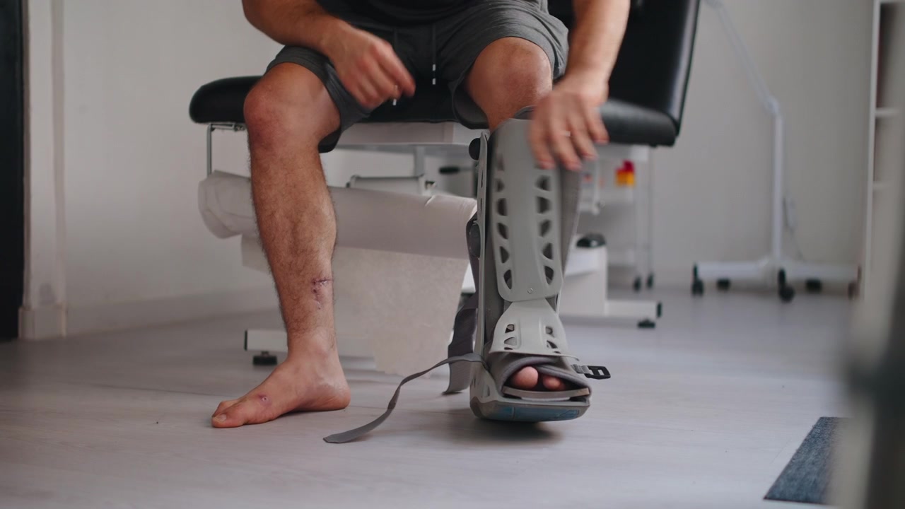 Man Removing Orthopedic Walking Boot After Leg Injury