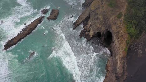 Vista-Aérea-De-Los-Acantilados-Y-La-Cueva-En-La-Playa-De-Karekare,-Nueva-Zelanda