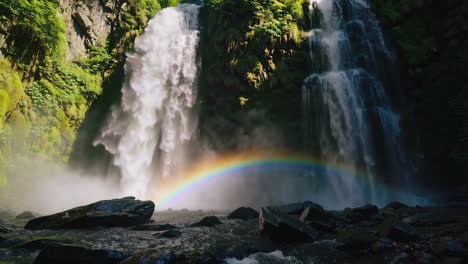 rainbow waterfall in lush rainforest