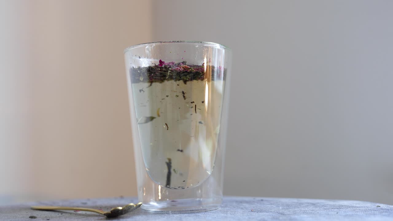 Versare acqua calda in un bicchiere a doppia parete di tisana.