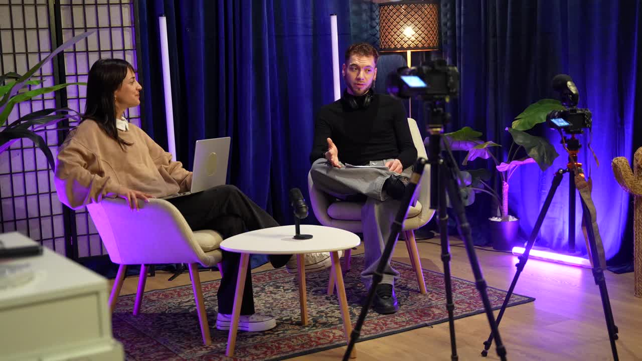 Uomo e donna che registrano un podcast o un'intervista in uno studio moderno