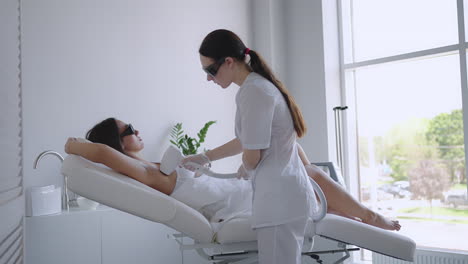 una cosmetóloga hace depilación láser de las axilas en un salón de belleza. eliminación de vello de las axilas. belleza y piel limpia
