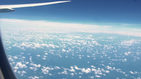 aircraft wing view from airplane with cloudy sky flying from australia to singapore - pov