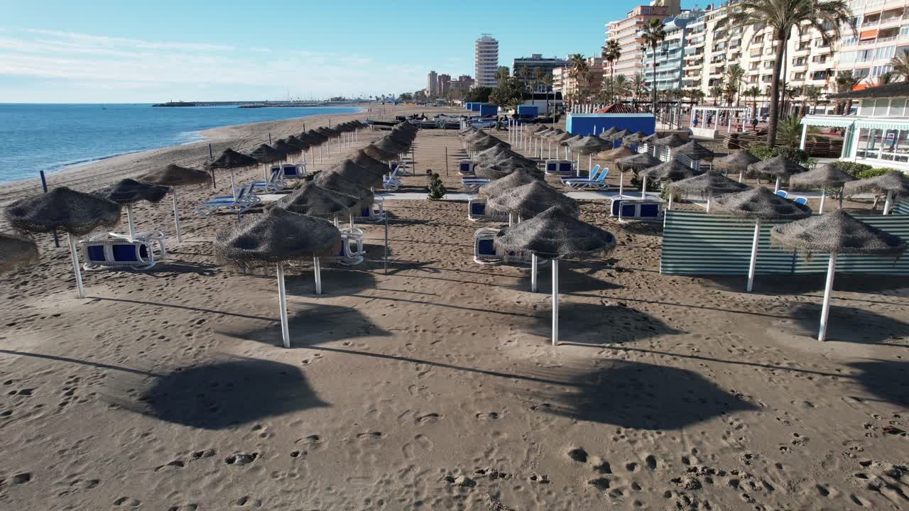 imágenes de drones sombrilla de paja tumbona en la playa del complejo de fuengirola con barcos