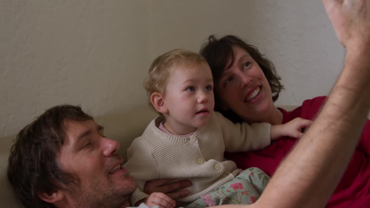 Side view of family taking picture in living room at home