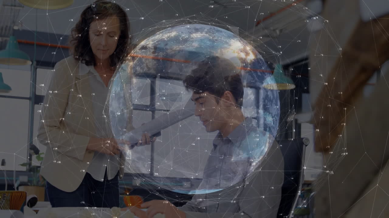 Man reviewing blueprints at desk while woman offering plans beside him, showing tech network globe