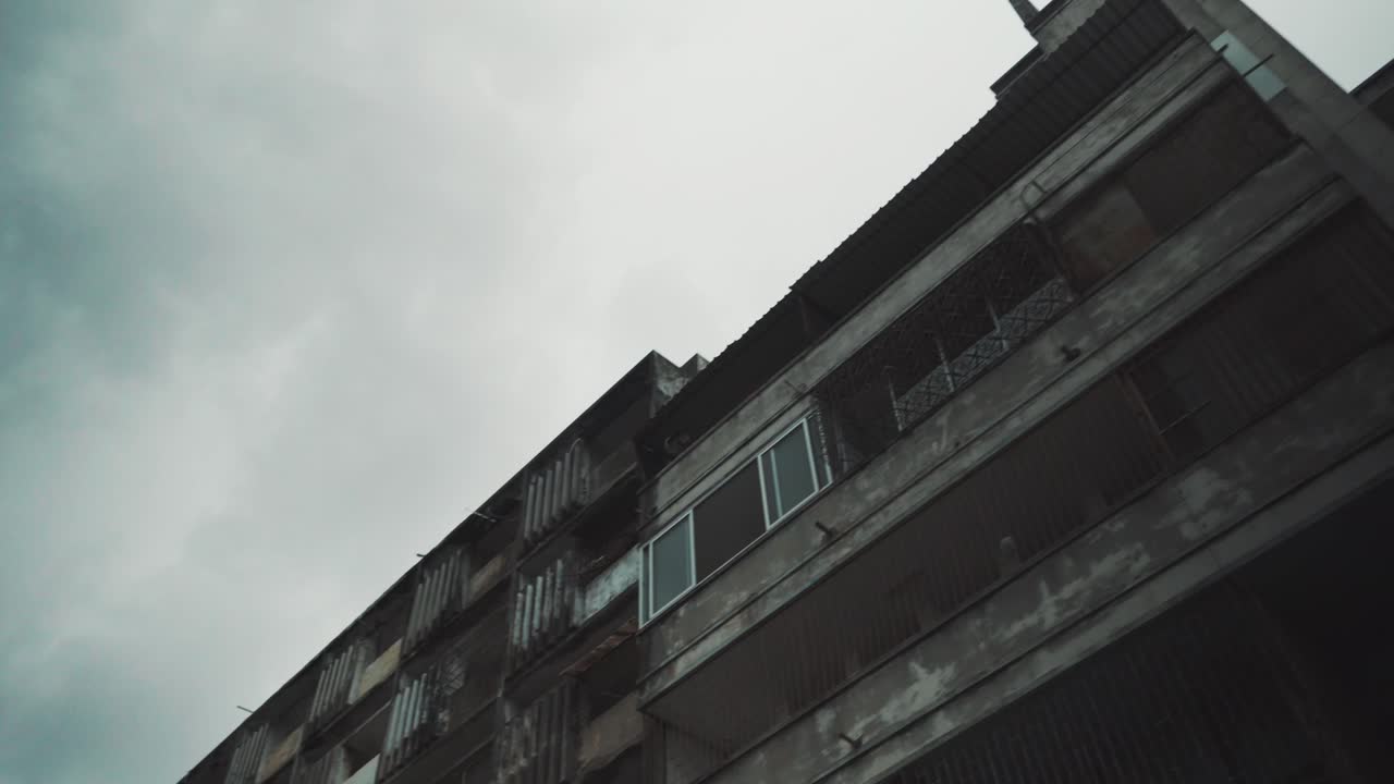 Slow panning shot of a creepy rundown apartment block in the heart of Maputo, Mozambique.
